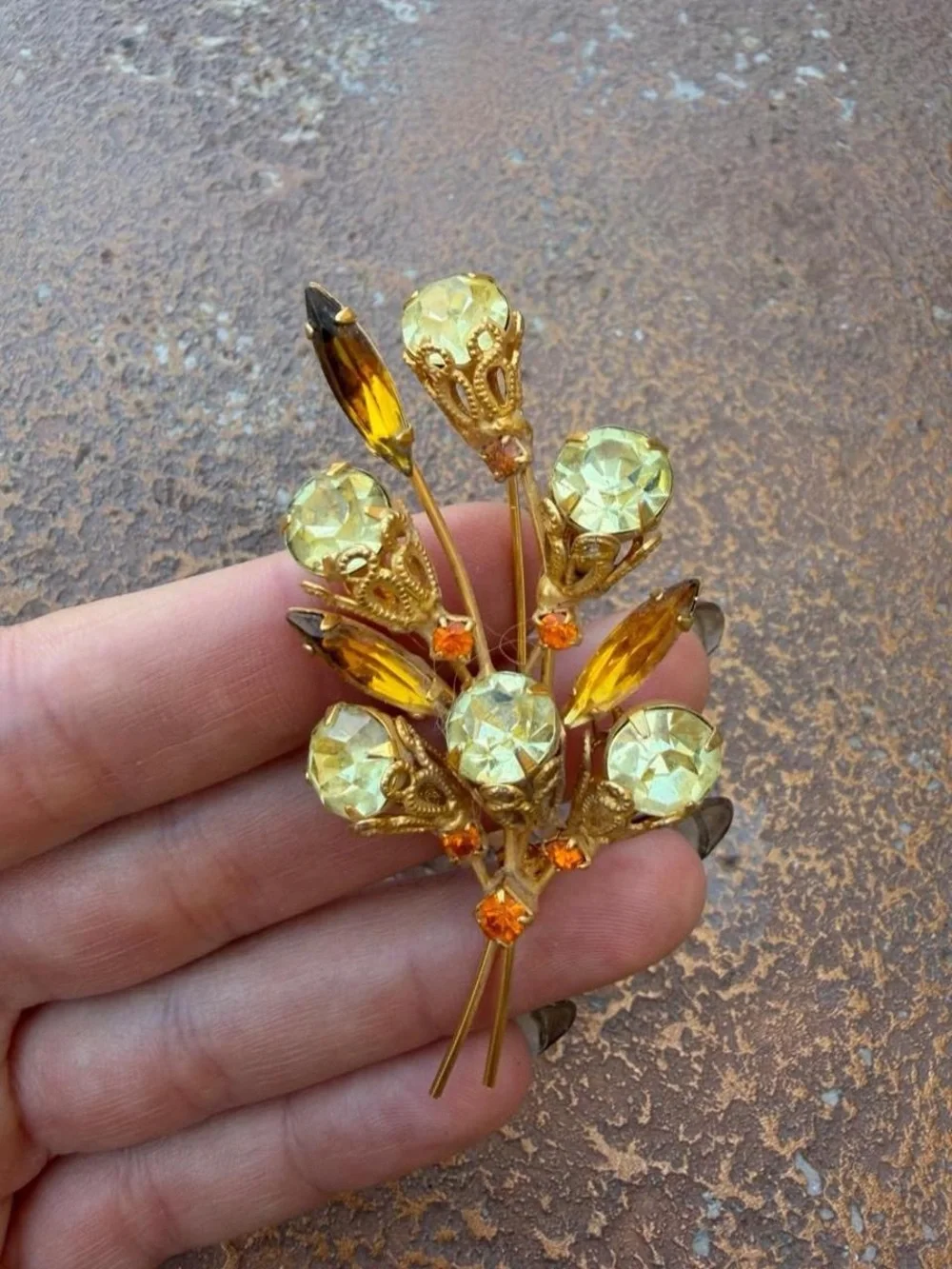Vintage 1960s brooch with gold-tone metal and light green and orange rhinestones